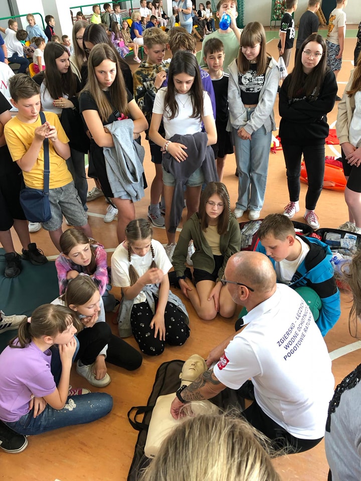 dzieci opserwujace pokaz pierwszej pomocy
